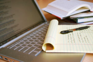 laptop with pen and books