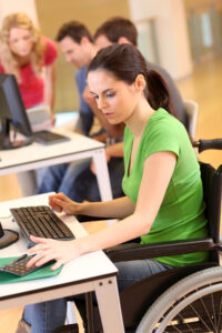 Young woman in wheelchair working in office